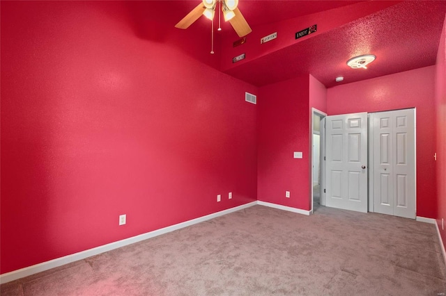 unfurnished bedroom featuring ceiling fan, a textured ceiling, and carpet flooring