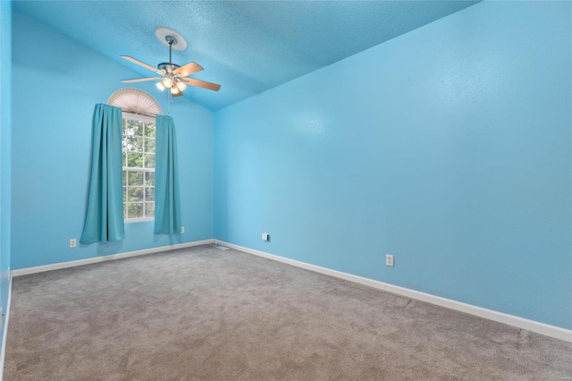 spare room with ceiling fan, lofted ceiling, and carpet flooring