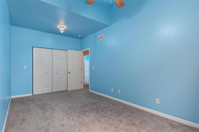 unfurnished bedroom with carpet floors, a closet, and ceiling fan