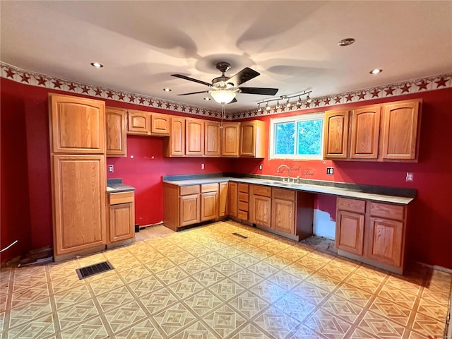 kitchen featuring built in desk, sink, and ceiling fan