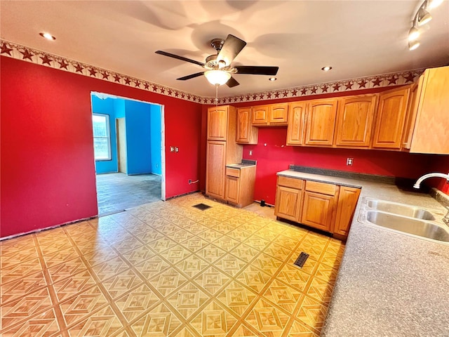 kitchen featuring ceiling fan and sink