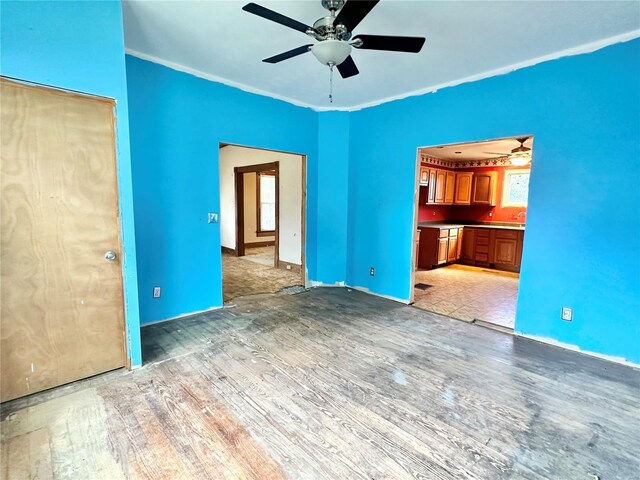 interior space with light hardwood / wood-style floors, ceiling fan, and crown molding