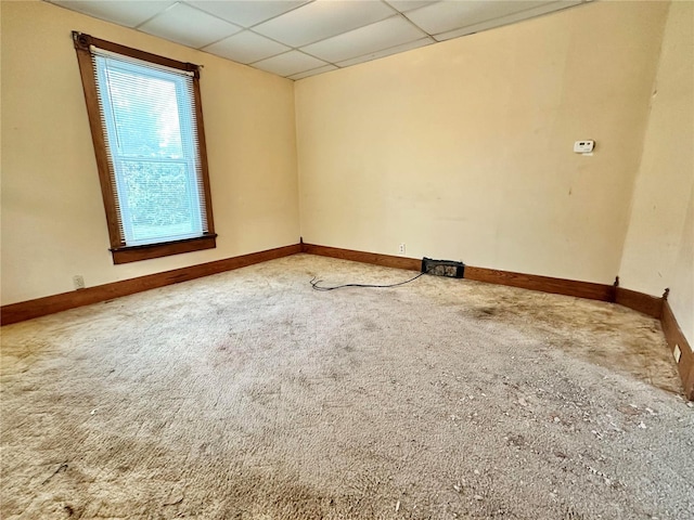 carpeted empty room with a drop ceiling