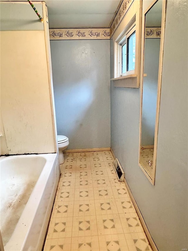 bathroom featuring a tub and toilet