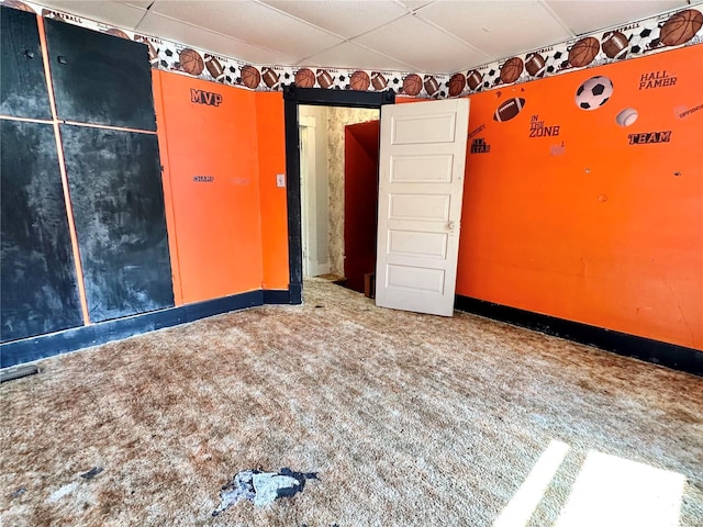 carpeted empty room with a paneled ceiling