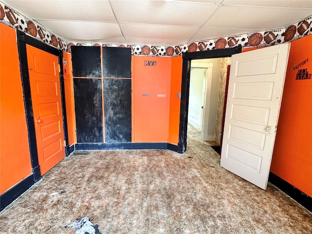 unfurnished bedroom featuring a drop ceiling and carpet flooring