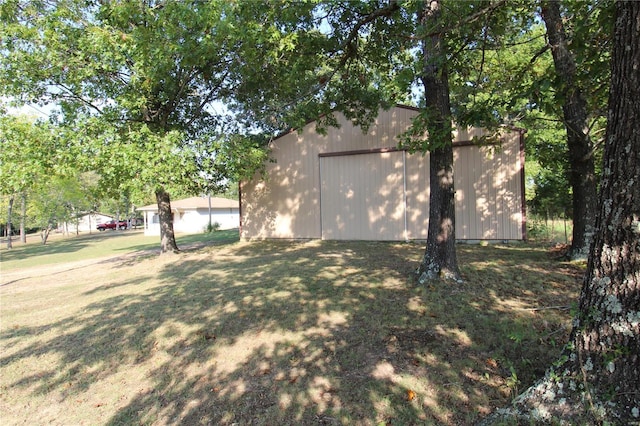 view of side of home featuring a yard and an outbuilding