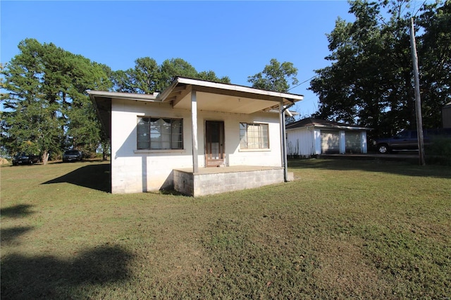 back of house with a porch and a yard