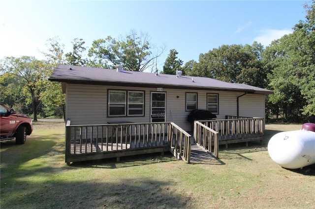 rear view of house featuring a deck and a yard