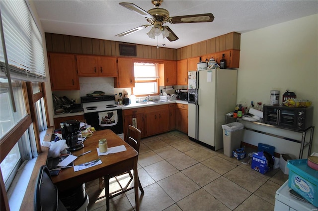 kitchen featuring ceiling fan, backsplash, light tile patterned floors, and white appliances