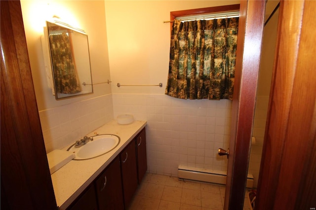 bathroom with tile walls, tile patterned floors, baseboard heating, and vanity