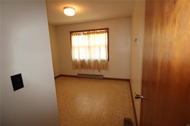 spare room with a textured ceiling and baseboard heating