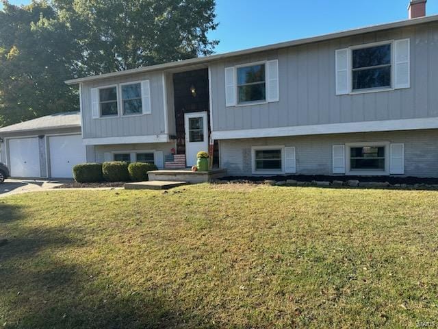 raised ranch with a garage and a front lawn