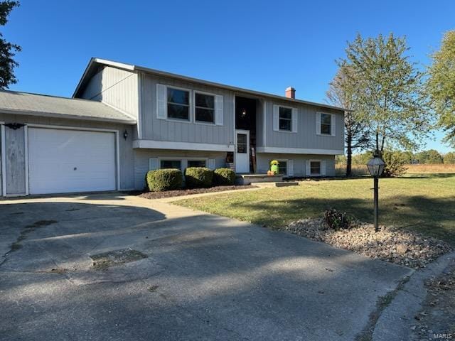 split foyer home featuring an attached garage, driveway, and a front lawn