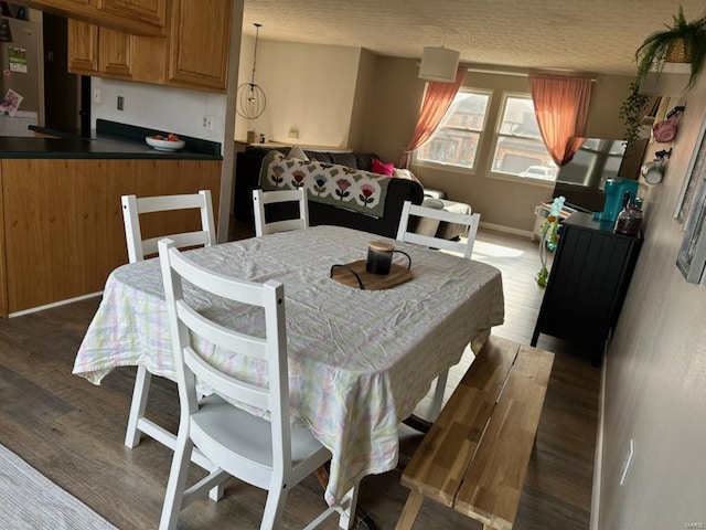 dining area with baseboards and wood finished floors