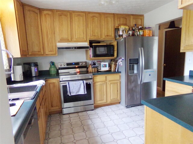 kitchen featuring stainless steel appliances, dark countertops, a sink, and ventilation hood