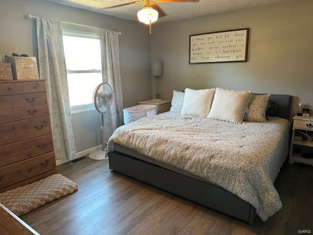 bedroom with a ceiling fan and wood finished floors