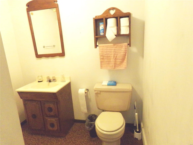 bathroom with toilet, baseboards, and vanity