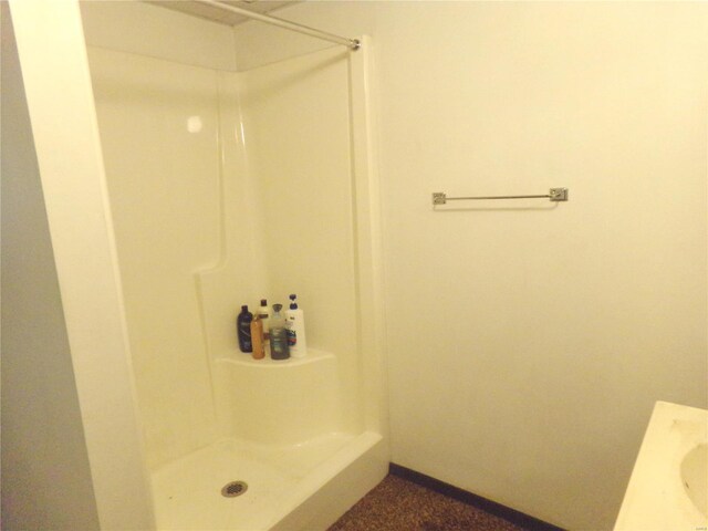 bathroom with baseboards and a shower