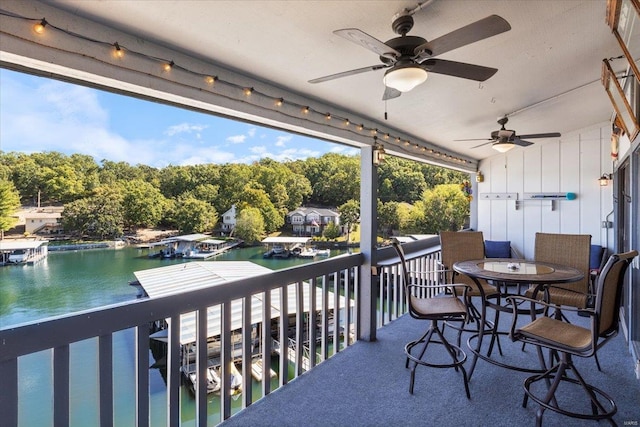 balcony with a water view and ceiling fan