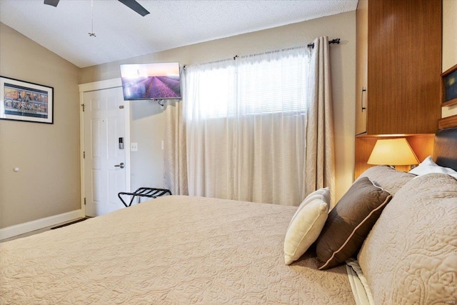 bedroom with a closet, vaulted ceiling, ceiling fan, and a textured ceiling