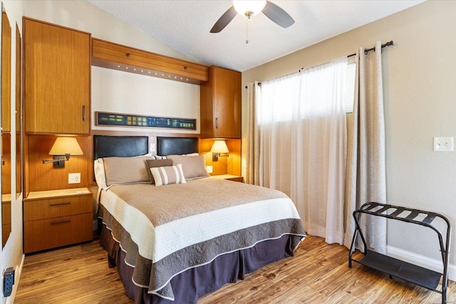 bedroom featuring ceiling fan, light wood-type flooring, and lofted ceiling