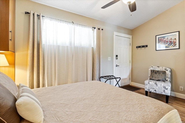 bedroom with ceiling fan, hardwood / wood-style flooring, and vaulted ceiling