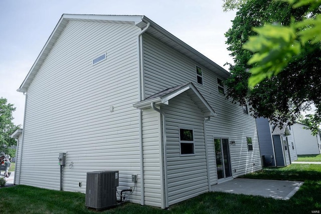 back of property with central air condition unit and a patio area