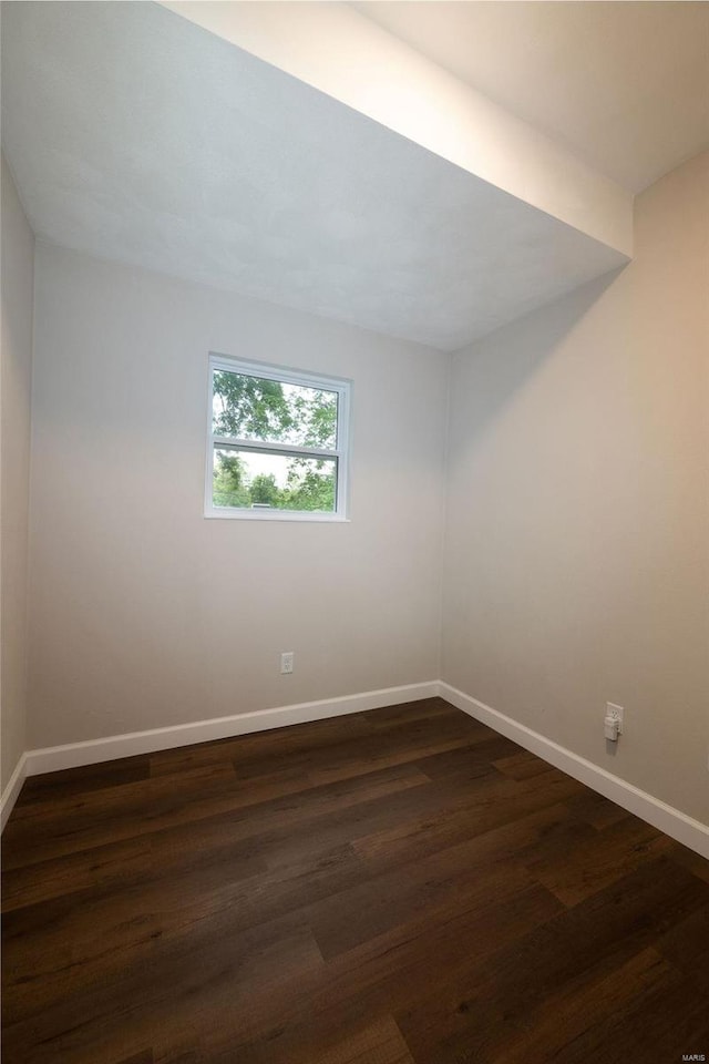 spare room with dark wood-type flooring