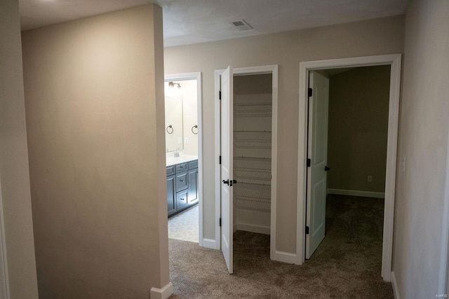 corridor featuring carpet floors and sink