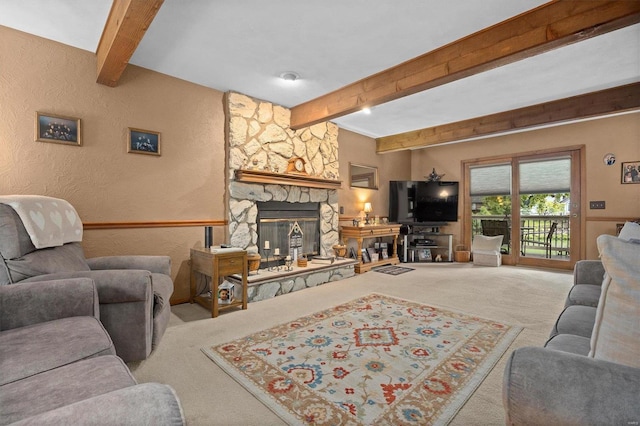 carpeted living room with beam ceiling and a stone fireplace