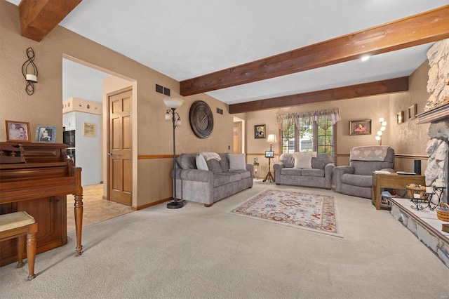 carpeted living room with a stone fireplace and beam ceiling