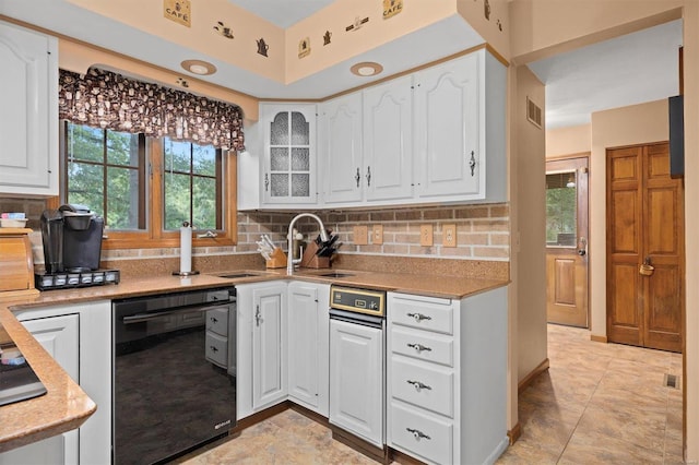 kitchen with decorative backsplash, white cabinets, black dishwasher, and light tile patterned flooring