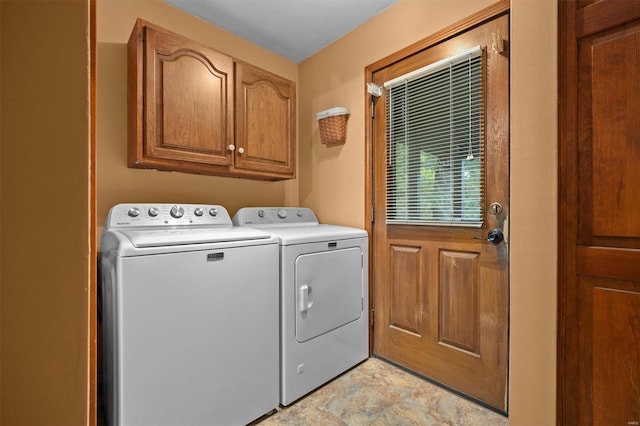 laundry room featuring washing machine and clothes dryer and cabinets