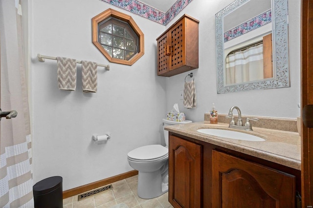 bathroom with vanity, toilet, and tile patterned floors