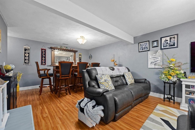 living room with beam ceiling and hardwood / wood-style floors