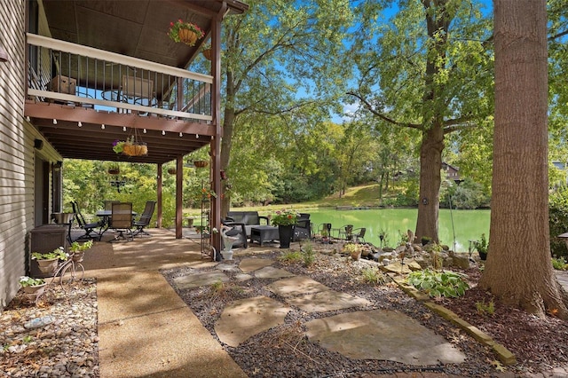 view of patio with a balcony and a water view