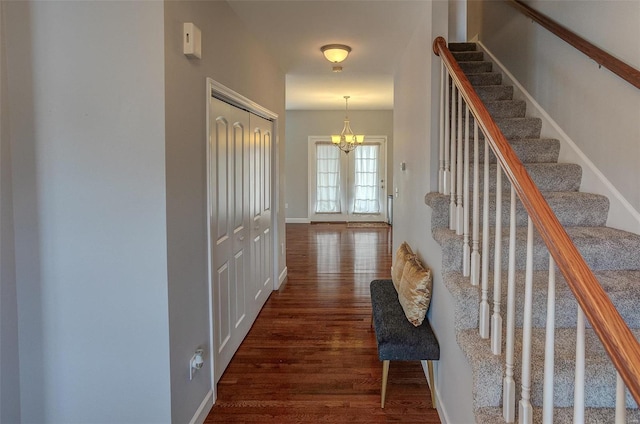 hall with a chandelier and dark hardwood / wood-style flooring