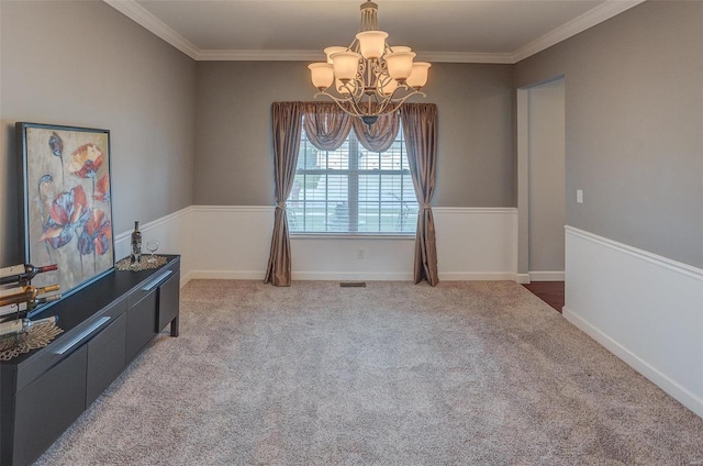 dining area with carpet flooring, crown molding, and a notable chandelier