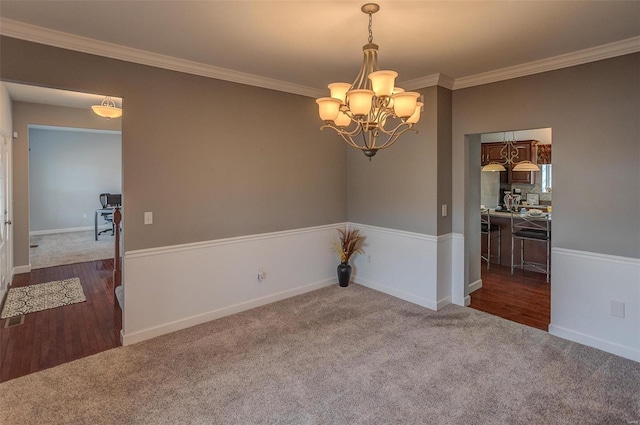 unfurnished room with an inviting chandelier, crown molding, and dark wood-type flooring