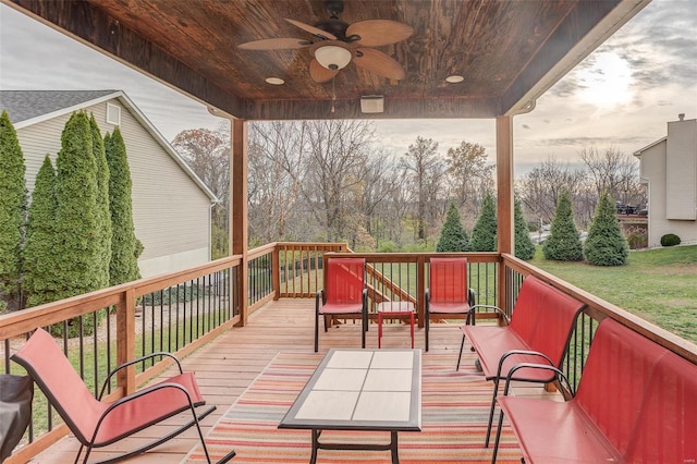 wooden deck featuring a lawn and ceiling fan