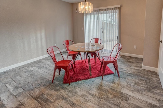 dining space featuring wood-type flooring and an inviting chandelier