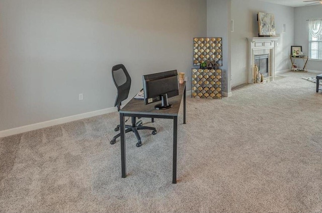 carpeted office space with ceiling fan