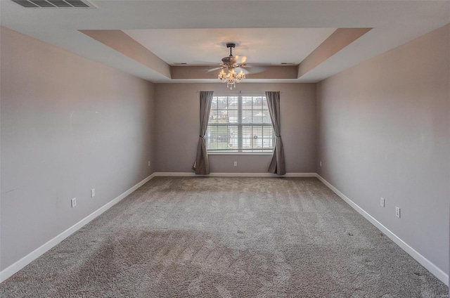 carpeted empty room featuring ceiling fan and a raised ceiling