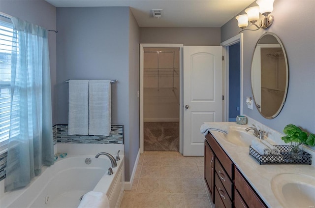 bathroom featuring tile patterned floors, a tub, vanity, and a chandelier