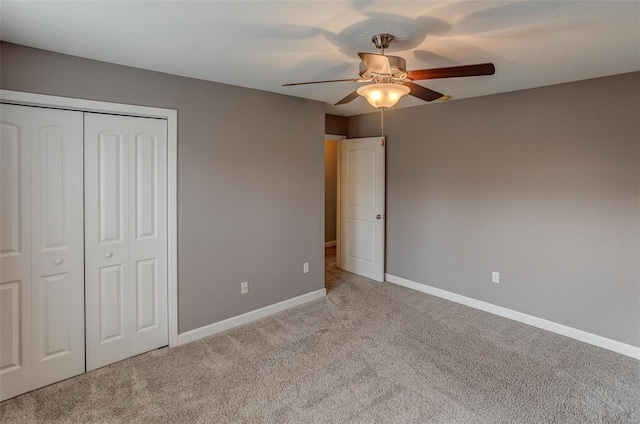 unfurnished bedroom with ceiling fan, light carpet, and a closet