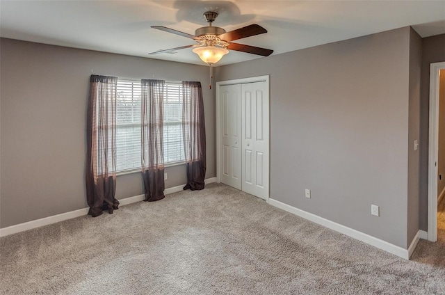 unfurnished bedroom featuring ceiling fan, a closet, and light carpet