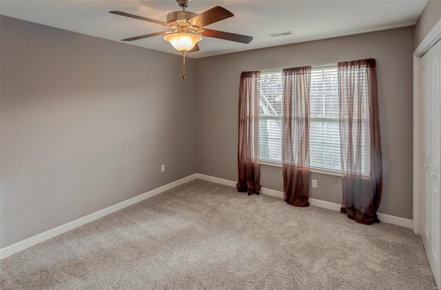 carpeted spare room featuring ceiling fan