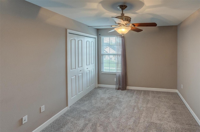 unfurnished bedroom featuring light carpet, a closet, and ceiling fan