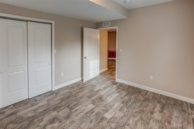 unfurnished bedroom with hardwood / wood-style flooring and a closet